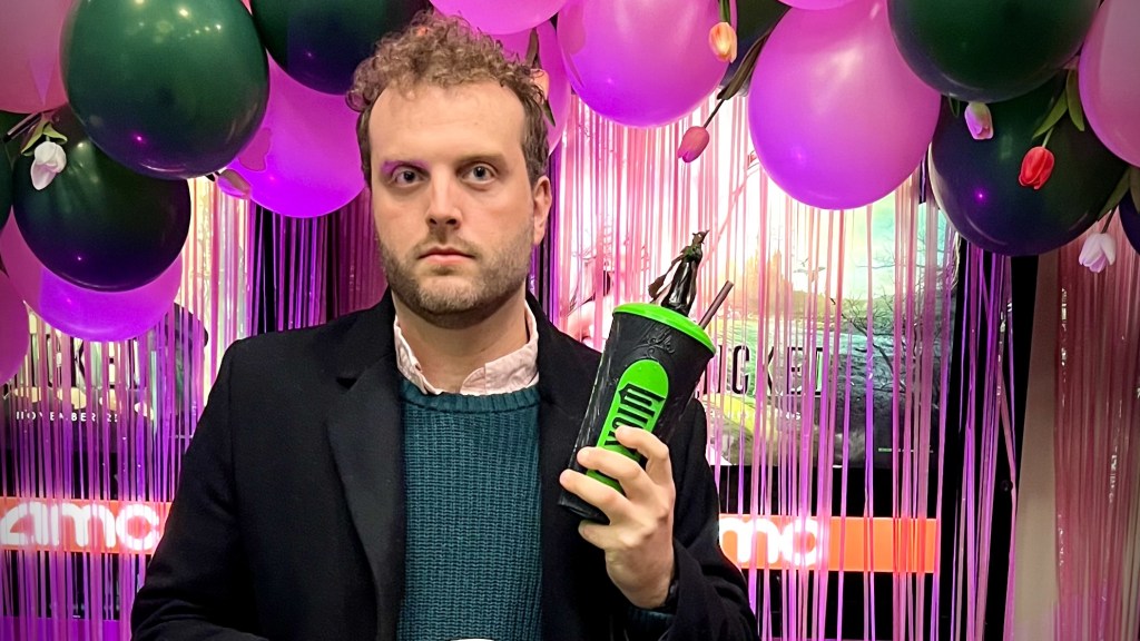 Tall man holding a Wicked cup